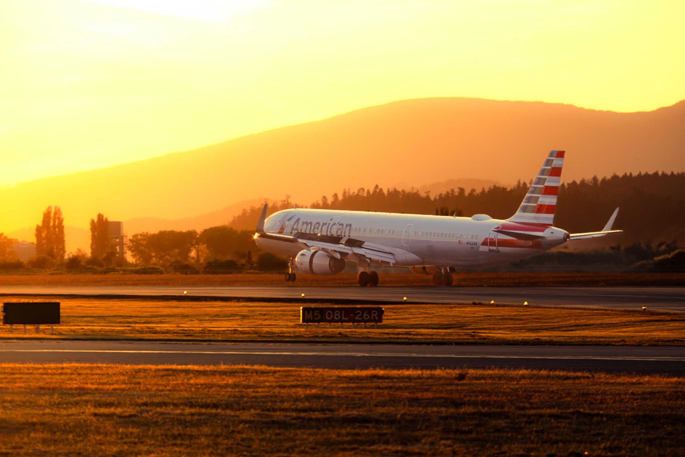Aircraft photographed on a runway in warm light